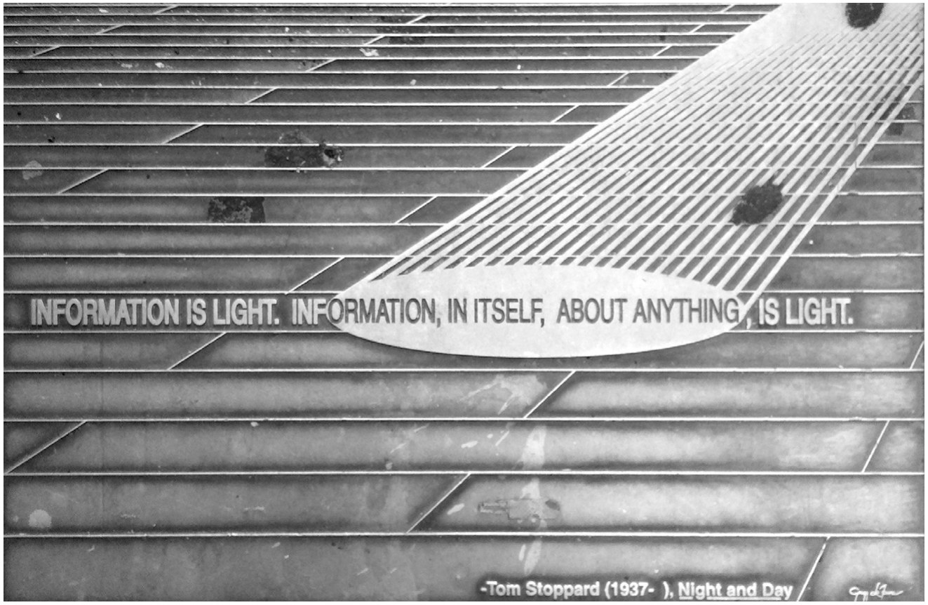 A floor of glass blocks crossed by a beam of projected light carrying the words “Information is light. Information, in itself, about anything, is light.” credited to Tom Stoppard, Night and Day