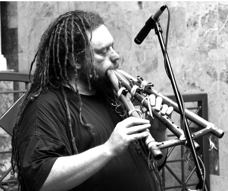 Jaron Lanier playing a long wind instrument into a microphone